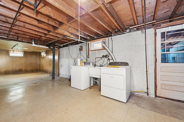 basement featuring washing machine and clothes dryer, tile patterned floors, and a sink