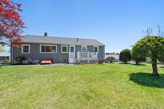 back of property with a lawn and a wooden deck