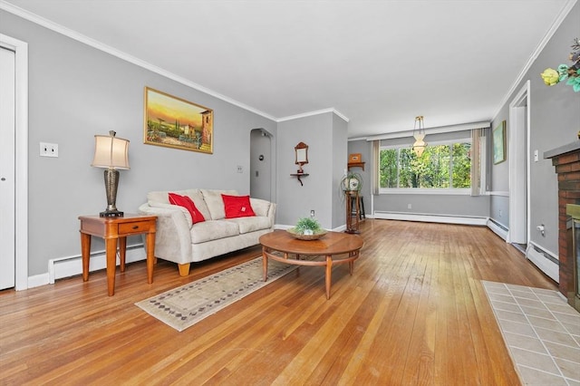 living area featuring arched walkways, a baseboard radiator, baseboard heating, and a fireplace