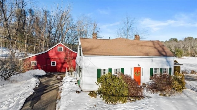 view of snowy exterior with a barn and an outdoor structure