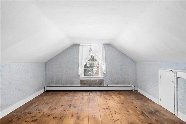 bonus room with baseboards, a baseboard heating unit, vaulted ceiling, and hardwood / wood-style floors