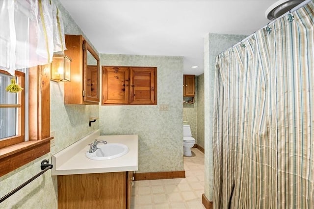 full bath with curtained shower, toilet, vanity, tile patterned floors, and wallpapered walls