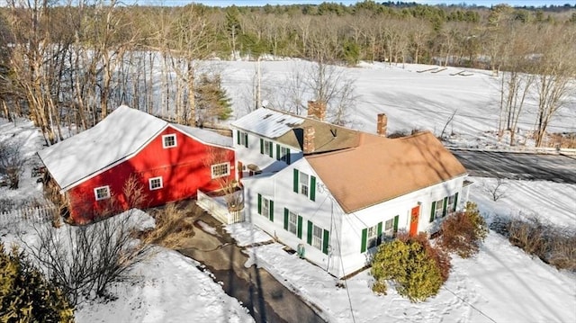 snowy aerial view featuring a forest view