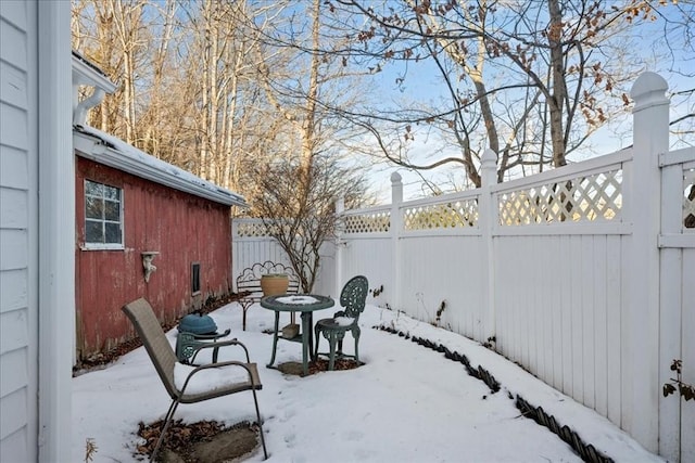 yard layered in snow with a fenced backyard