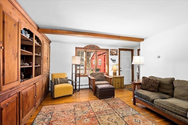 living area featuring a baseboard heating unit, light wood-type flooring, and beam ceiling