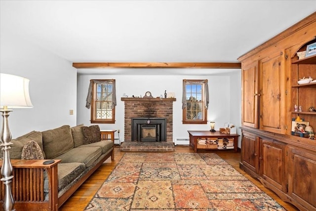 living room featuring a brick fireplace, a baseboard heating unit, and wood finished floors