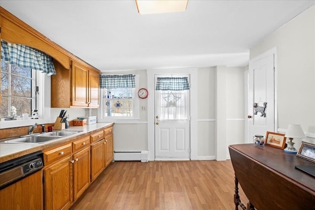 kitchen featuring a sink, a healthy amount of sunlight, light wood-style floors, baseboard heating, and dishwasher