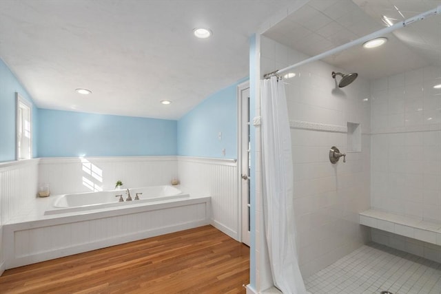 full bath with a garden tub, recessed lighting, a wainscoted wall, wood finished floors, and tiled shower