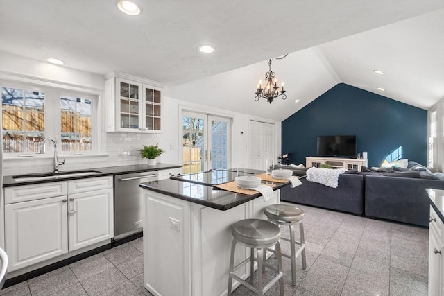 kitchen featuring recessed lighting, dark countertops, granite finish floor, a sink, and dishwasher