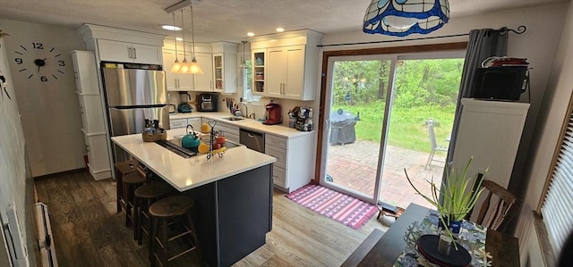 3 Kenneth St, Sandwich, MA 02537 - kitchen with white cabinets, wood finished floors, a sink, light countertops, and stainless steel appliances