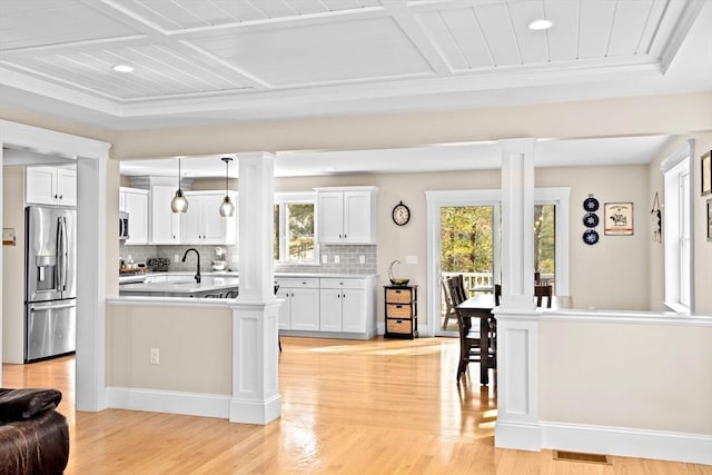 kitchen featuring a healthy amount of sunlight, stainless steel appliances, and decorative columns