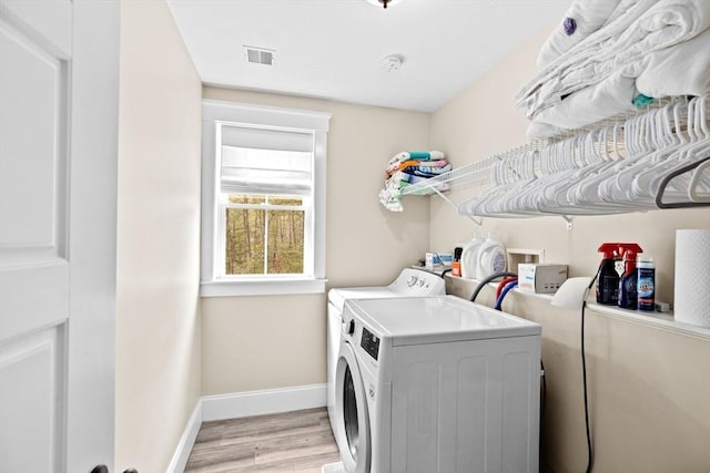 washroom with laundry area, baseboards, visible vents, and washing machine and clothes dryer