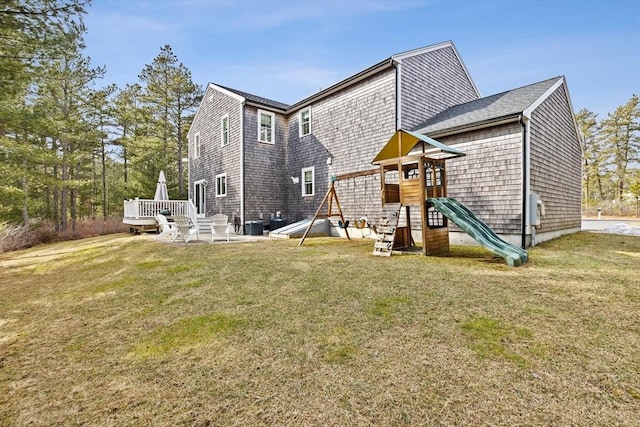 rear view of house with a playground and a yard