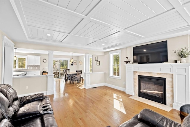 living area with baseboards, a fireplace with flush hearth, wood ceiling, light wood-style floors, and coffered ceiling