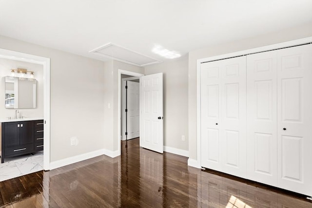765 S Mammoth Rd, Manchester, NH 03109 - unfurnished bedroom with wood finished floors, a sink, attic access, a closet, and baseboards