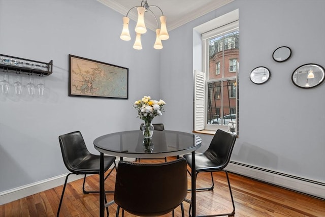 dining area featuring ornamental molding, baseboard heating, an inviting chandelier, and hardwood / wood-style floors