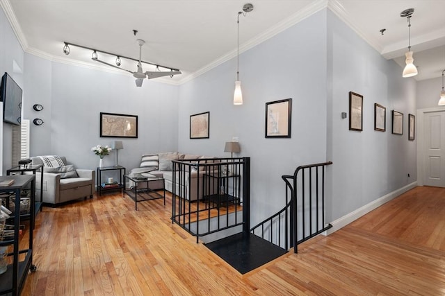 interior space featuring hardwood / wood-style flooring, track lighting, and crown molding