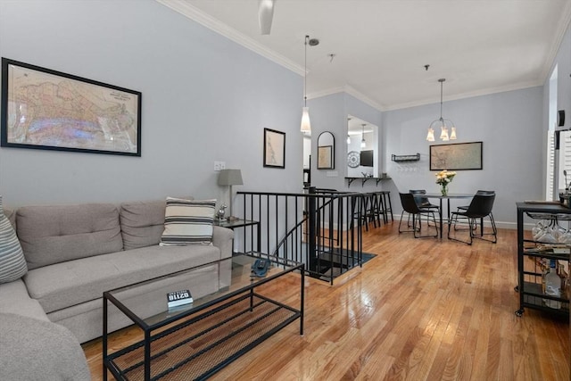 living room featuring an inviting chandelier, crown molding, and hardwood / wood-style floors