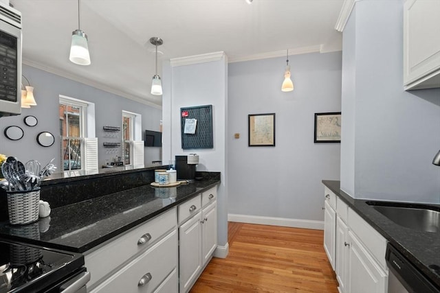 kitchen with decorative light fixtures, white cabinets, ornamental molding, and appliances with stainless steel finishes