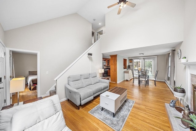 239 Upper County Rd, Dennis, MA 02660 - living room featuring stairway, high vaulted ceiling, ceiling fan, and light wood-style flooring