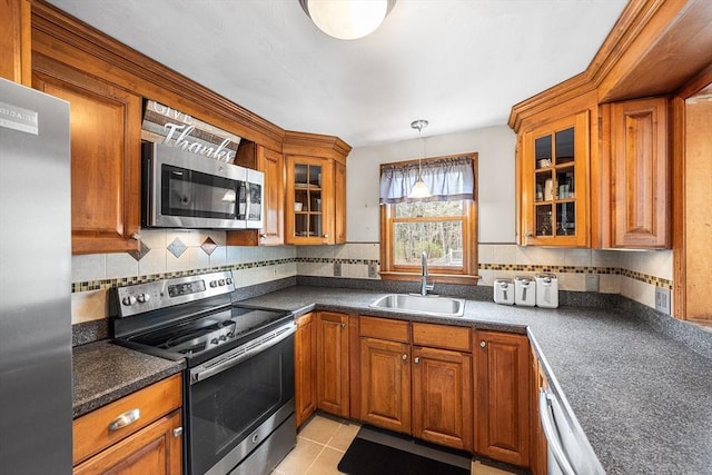 239 Upper County Rd, Dennis, MA 02660 - kitchen with appliances with stainless steel finishes, a sink, brown cabinetry, and dark countertops
