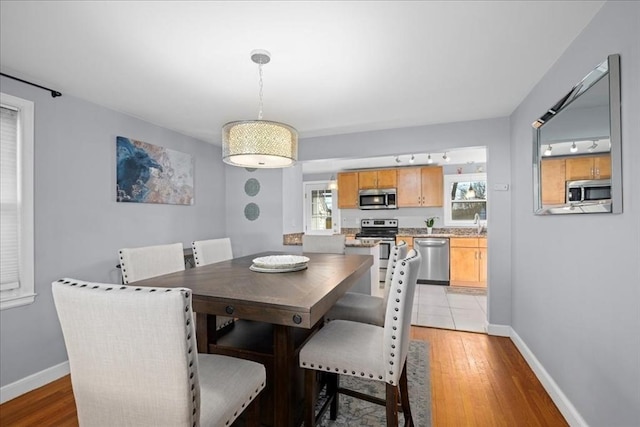 dining area featuring baseboards and light wood-style floors