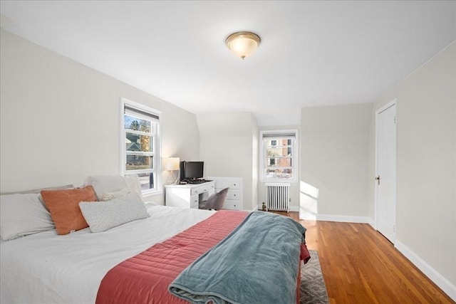 bedroom featuring radiator, baseboards, and light wood finished floors