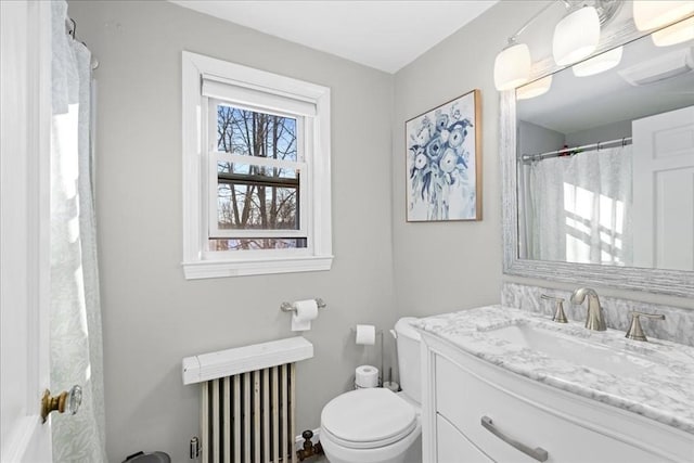 bathroom with vanity, toilet, and radiator heating unit