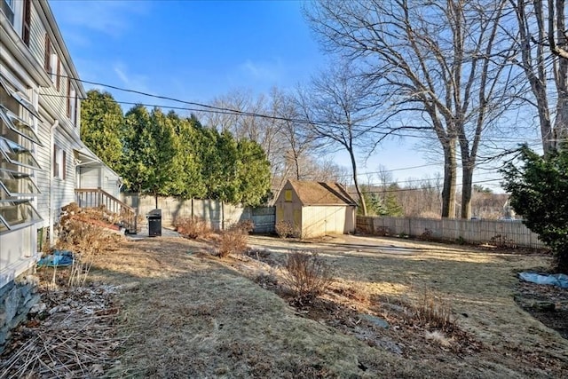 view of yard with an outbuilding, entry steps, a storage shed, and fence