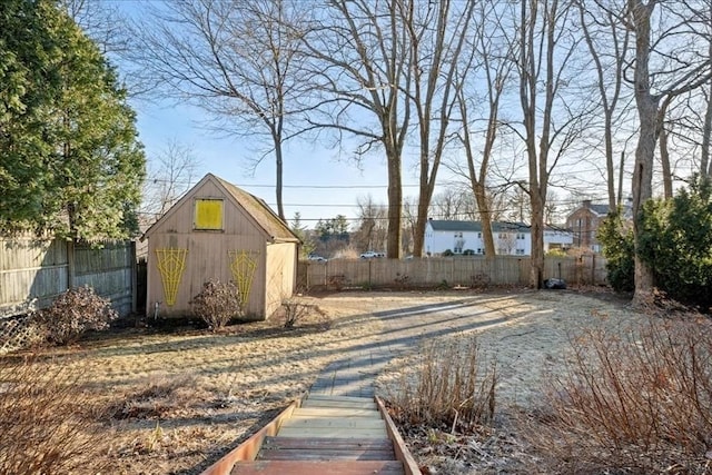 view of yard with a storage unit, an outbuilding, and a fenced backyard