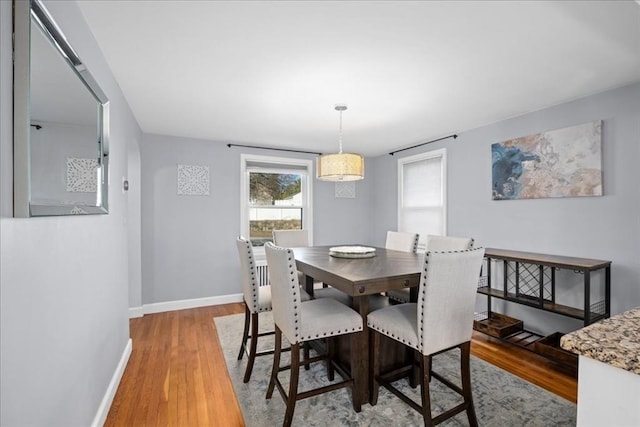 dining room featuring baseboards and light wood-type flooring