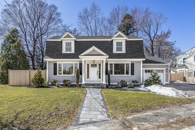 colonial inspired home with a front lawn, aphalt driveway, fence, an attached garage, and a shingled roof