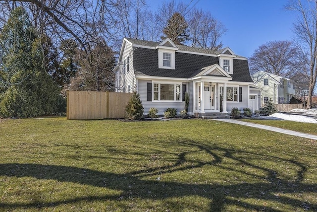 view of front of home featuring a front yard, fence, a gambrel roof, and roof with shingles