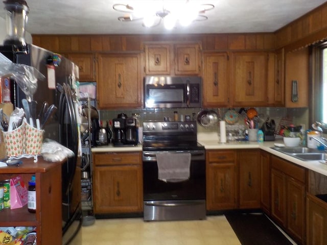 545 Douglas Rd, Northbridge, MA 01588 - kitchen featuring electric range, stainless steel microwave, brown cabinetry, light countertops, and a sink