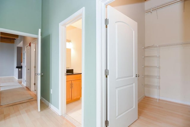 hallway featuring baseboards and light wood-style floors