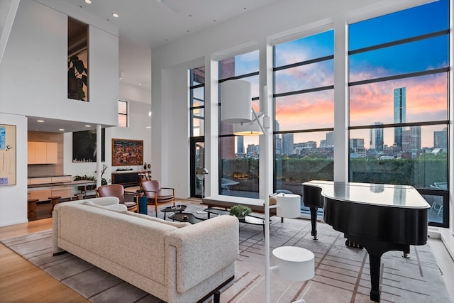 living room with a towering ceiling and light hardwood / wood-style floors