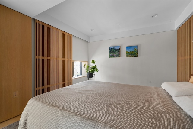 bedroom featuring wood walls and wood-type flooring