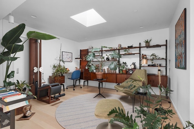 living area featuring a skylight and light hardwood / wood-style flooring