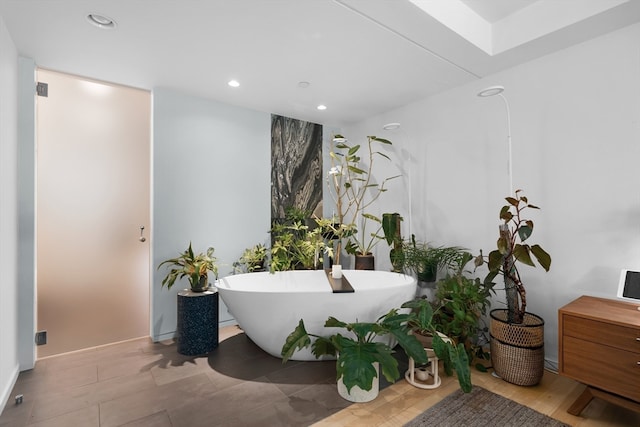 bathroom with a bath and hardwood / wood-style floors