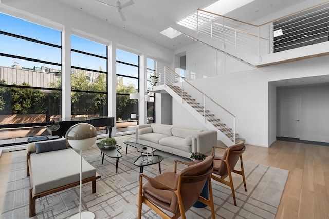 living room featuring a skylight and light hardwood / wood-style flooring