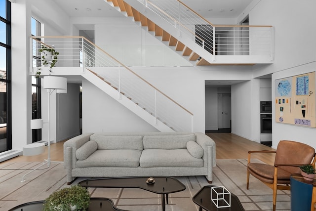 living room with hardwood / wood-style flooring and a towering ceiling