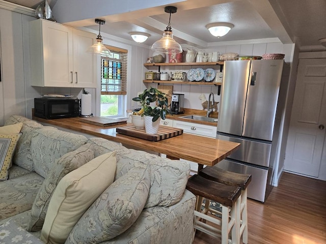 230 Gosnold St Unit 1A, Barnstable, MA 02601 - kitchen with freestanding refrigerator, a sink, black microwave, wood finished floors, and wooden counters