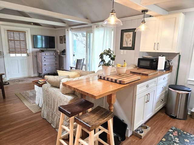 230 Gosnold St Unit 1A, Barnstable, MA 02601 - kitchen with butcher block counters, black microwave, wood finished floors, white cabinetry, and beam ceiling