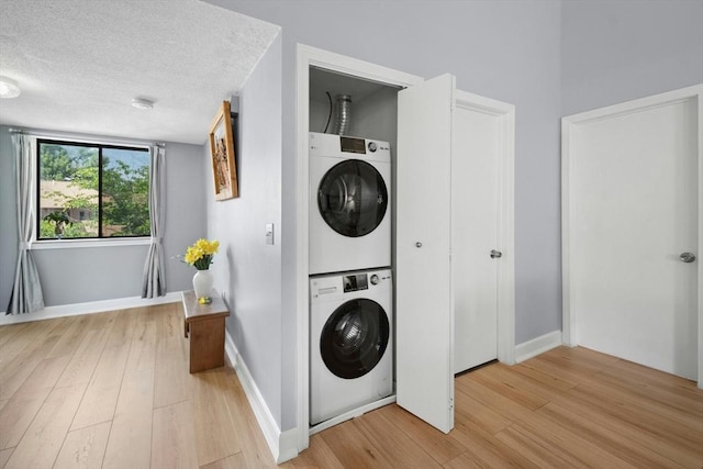 243 Trailside Way Unit 243, Ashland, MA 01721 - laundry room featuring stacked washer / dryer, light wood-style flooring, and baseboards