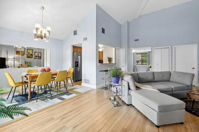 243 Trailside Way Unit 243, Ashland, MA 01721 - living room with a chandelier, high vaulted ceiling, light wood-type flooring, and baseboards