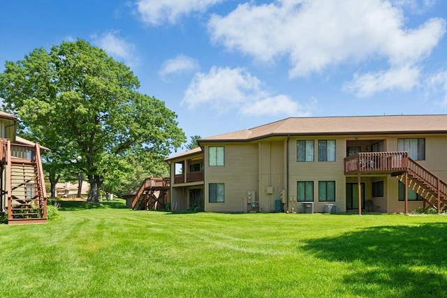 243 Trailside Way Unit 243, Ashland, MA 01721 - rear view of property with stairs, a wooden deck, a lawn, and central AC