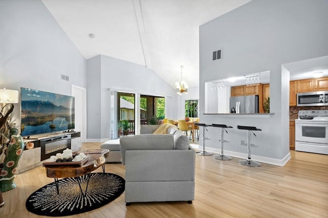243 Trailside Way Unit 243, Ashland, MA 01721 - living room with high vaulted ceiling, light wood finished floors, a chandelier, and baseboards