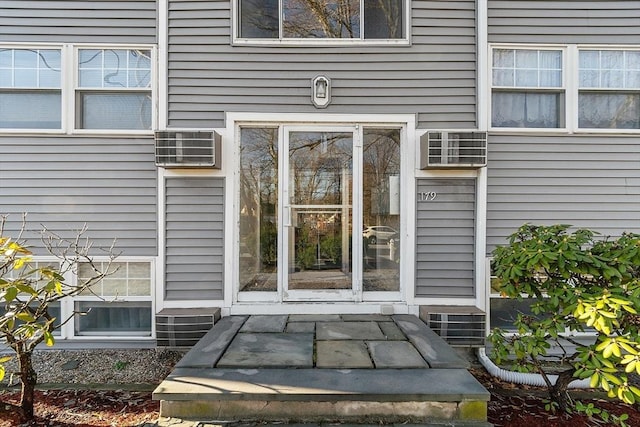 doorway to property with a wall mounted AC