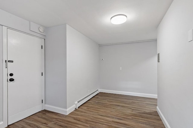 foyer with a baseboard heating unit and wood-type flooring