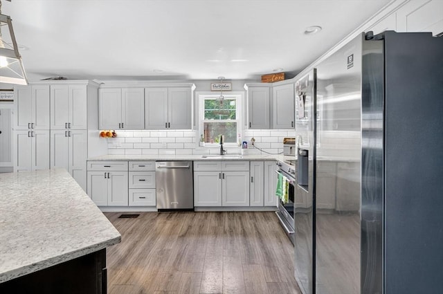 29 Edgemere Dr, Seekonk, MA 02771 - kitchen featuring appliances with stainless steel finishes, light wood-type flooring, backsplash, recessed lighting, and light stone counters